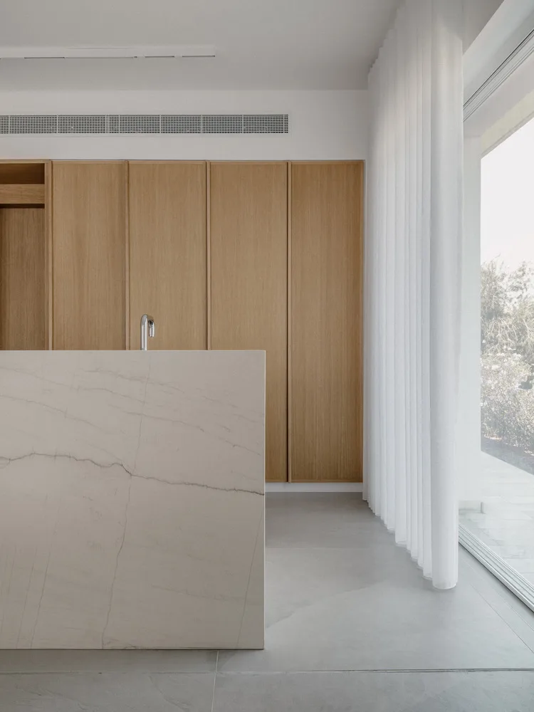 Sculpture like exposed concrete runs through the entire narrow rectangular flat design