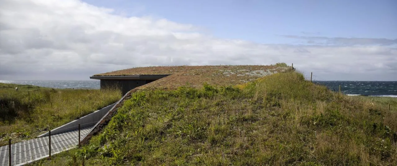 A vacation home design that coexists with sand dunes and the sea, showcasing the natural poetic and expansive beauty of the Norwegian coast