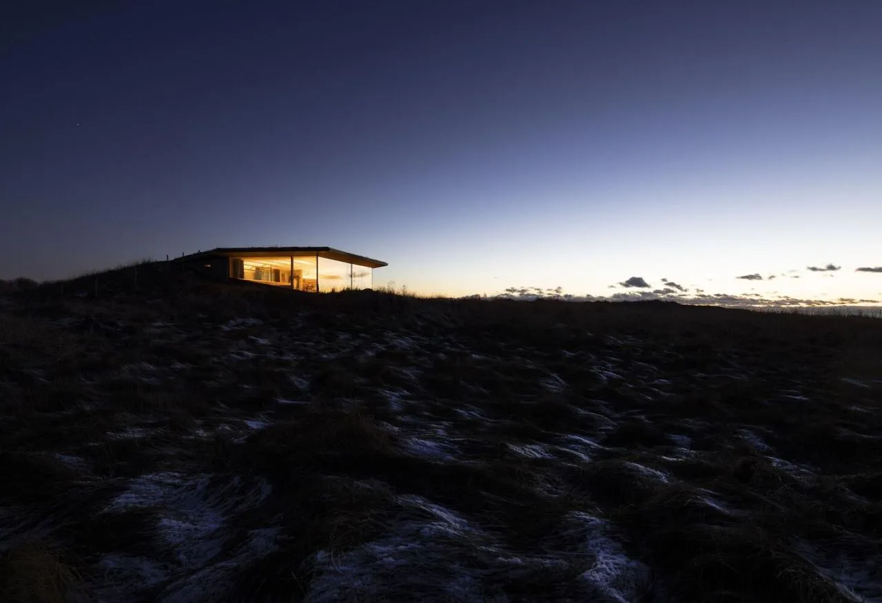 A vacation home design that coexists with sand dunes and the sea, showcasing the natural poetic and expansive beauty of the Norwegian coast