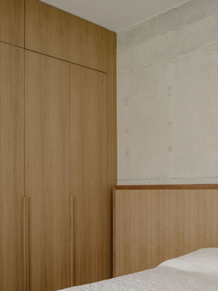 Sculpture like exposed concrete runs through the entire narrow rectangular flat design