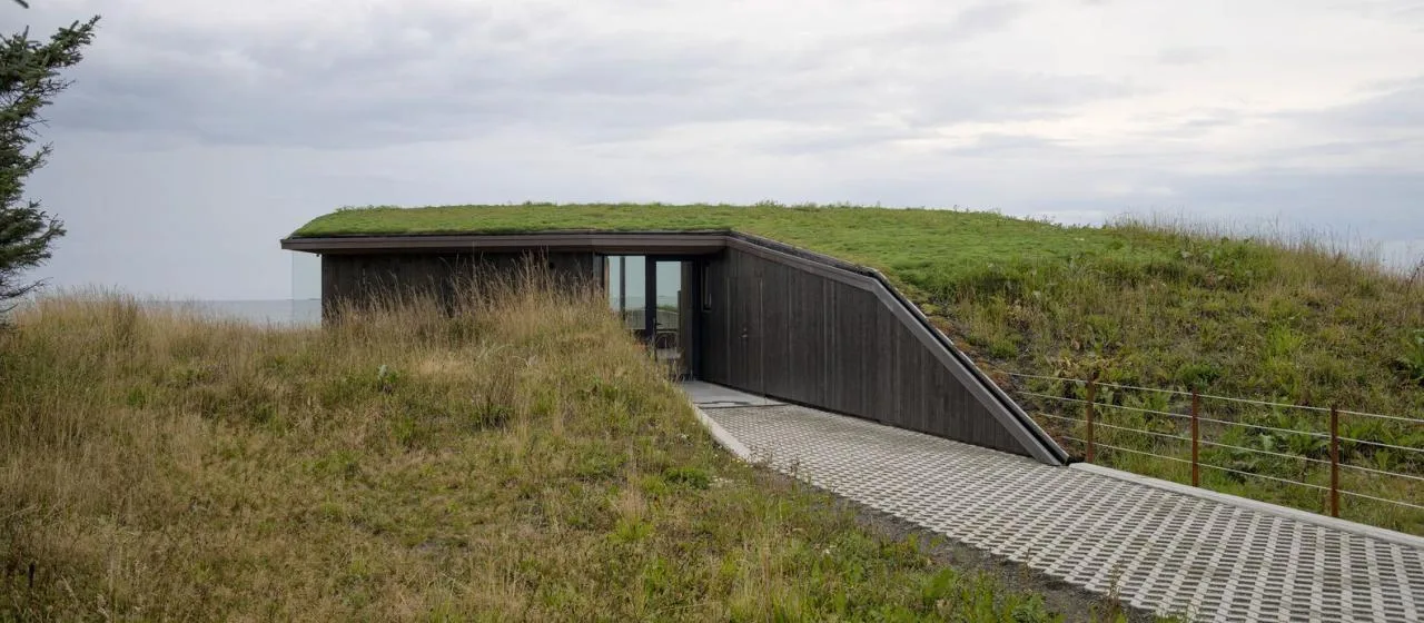 A vacation home design that coexists with sand dunes and the sea, showcasing the natural poetic and expansive beauty of the Norwegian coast