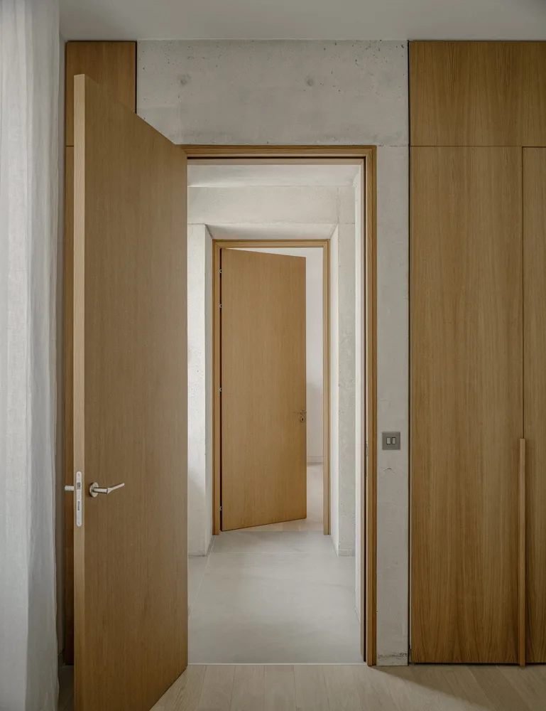 Sculpture like exposed concrete runs through the entire narrow rectangular flat design