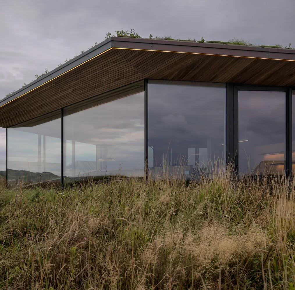 A vacation home design that coexists with sand dunes and the sea, showcasing the natural poetic and expansive beauty of the Norwegian coast
