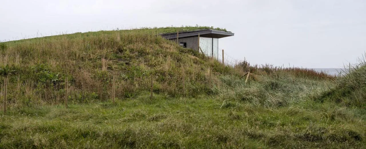 A vacation home design that coexists with sand dunes and the sea, showcasing the natural poetic and expansive beauty of the Norwegian coast