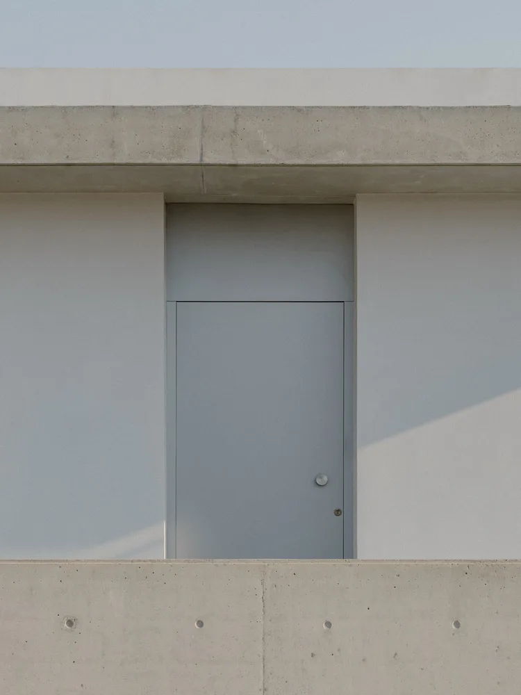 Sculpture like exposed concrete runs through the entire narrow rectangular flat design