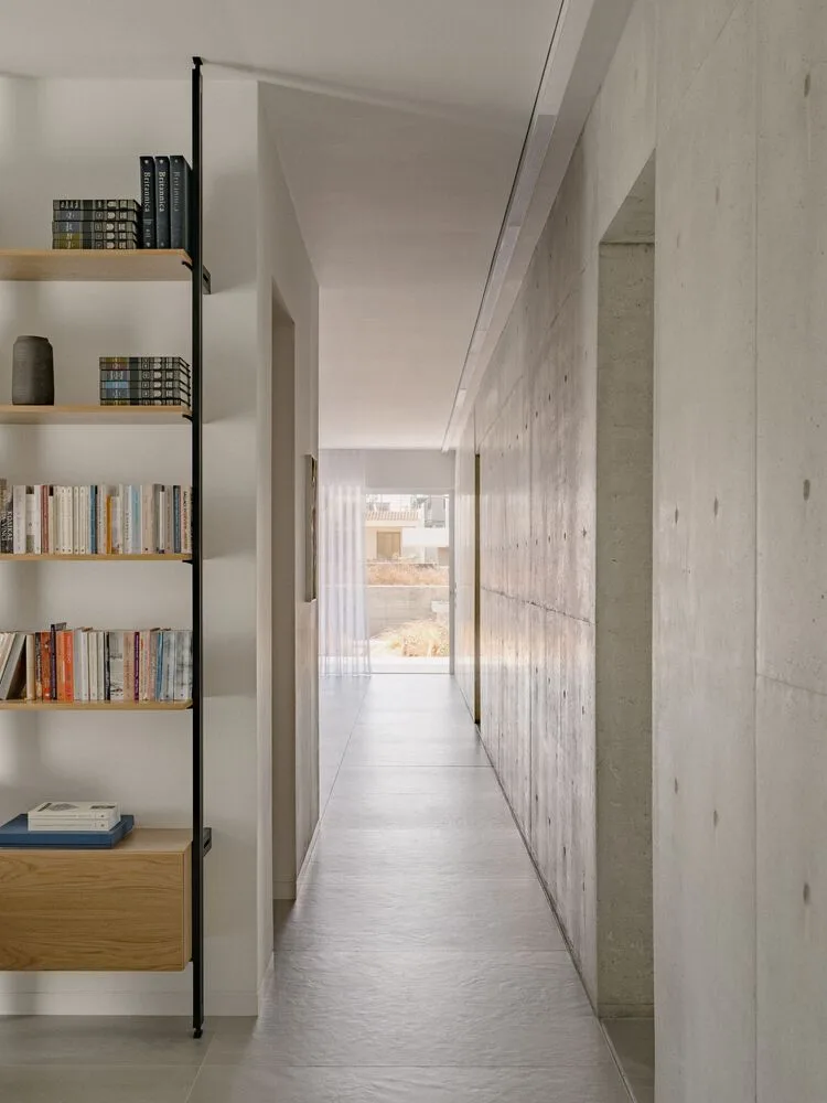 Sculpture like exposed concrete runs through the entire narrow rectangular flat design