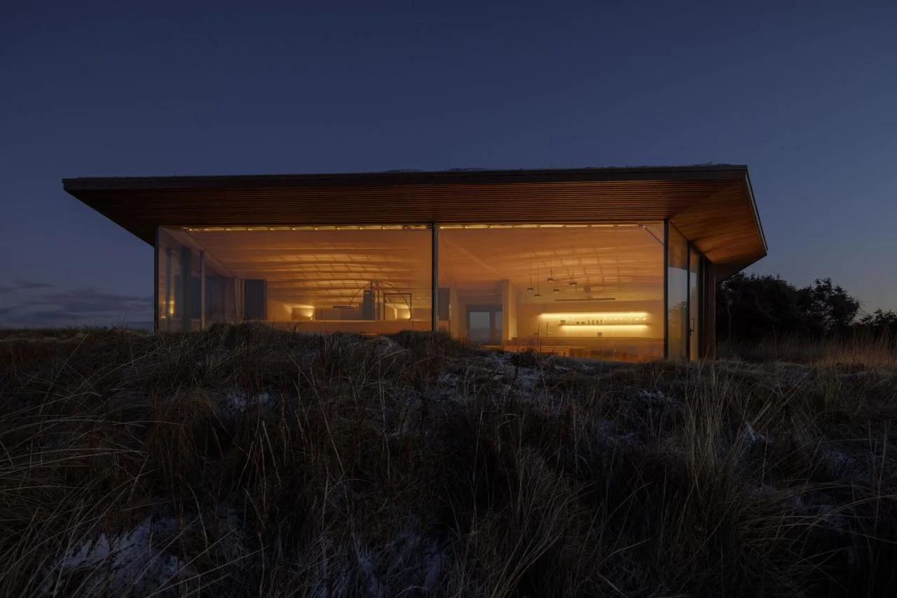 A vacation home design that coexists with sand dunes and the sea, showcasing the natural poetic and expansive beauty of the Norwegian coast